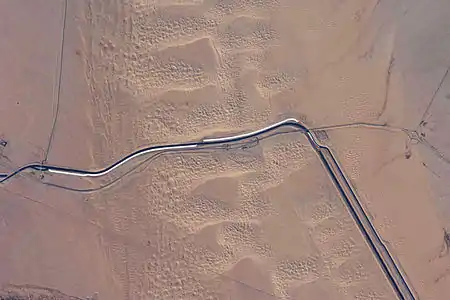 This image captures about 15 kilometers (9.3&nbsp;mi) of the All-American Canal just west of Yuma, Arizona; photo is taken of the southern section of the Algodones Dunes