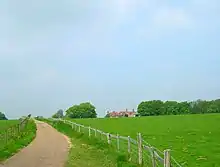 country land, green fields with old house in the background