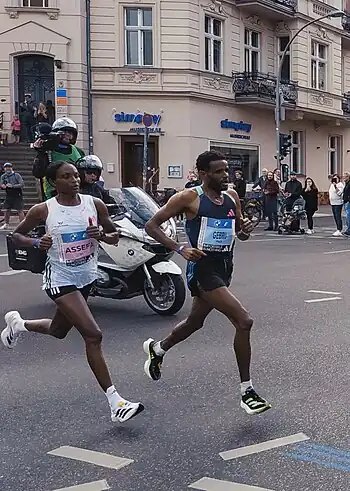 World record winner Tigst Assefa (left) about 25 km (16 mi) into the 2023 Berlin Marathon, alongside pacemaker Girmay Birhanu Gebru