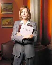 Allison Janney, pictured in costume as C. J. Cregg, for a promotional shoot