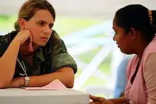 A nurse listens to a young woman
