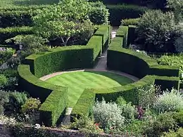 a circular enclosure of green hedging surrounding a lawn