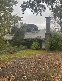 exterior of buff bricked building, in amongst foliage