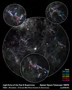 The infrared echo caused by the Cassiopeia&nbsp;A supernova seen by Spitzer. The image was processed in a way that the infrared echo appears colored while dust clouds remain grey. North is on the left.