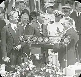 Lindbergh looks on as President Calvin Coolidge presents her son with the Distinguished Flying Cross (June&nbsp;11,&nbsp;1927)