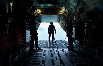 Silhouetted figures in the cargo bay of a large aircraft