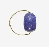 Ancient Egyptian scarab finger ring; 1850–1750&nbsp;BC; lapis lazuli scarab set in gold plate and on a gold wire ring lapis-lazuli; diameter: 2.5&nbsp;cm, the scarab: 1.8&nbsp;cm; Metropolitan Museum of Art