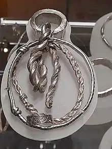 An armband and other silver items, looking highly polished and shiny