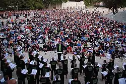 Choir on a beach with conductor and audience
